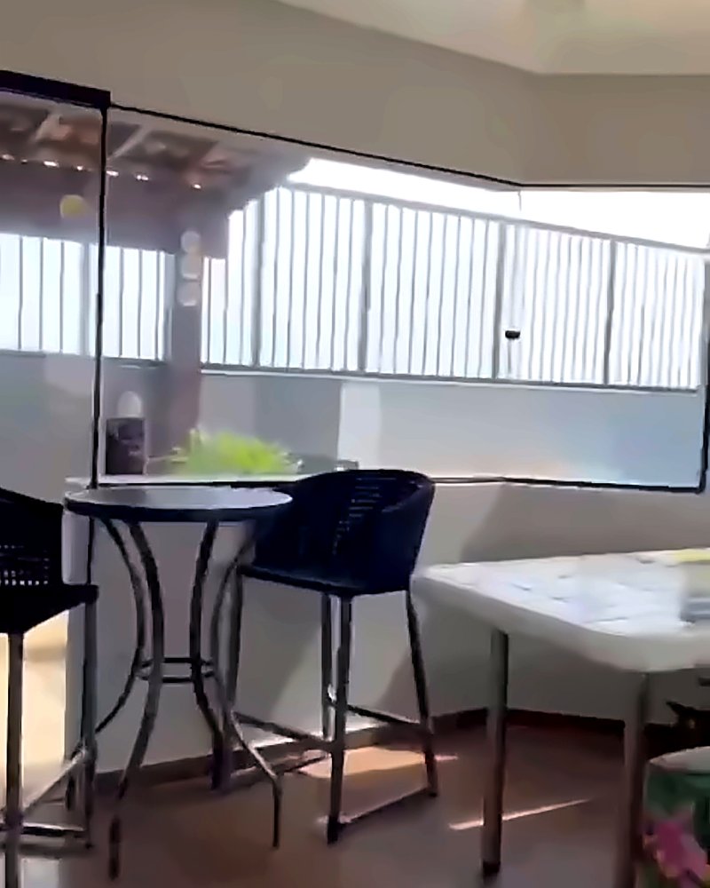 Área gourmet coberta com mesa alta e banquetas