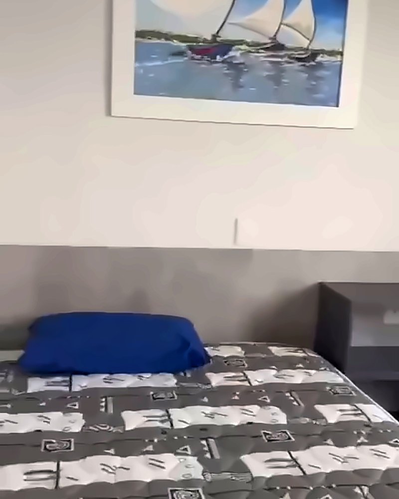 Quarto com duas camas de solteiro e quadro de veleiros