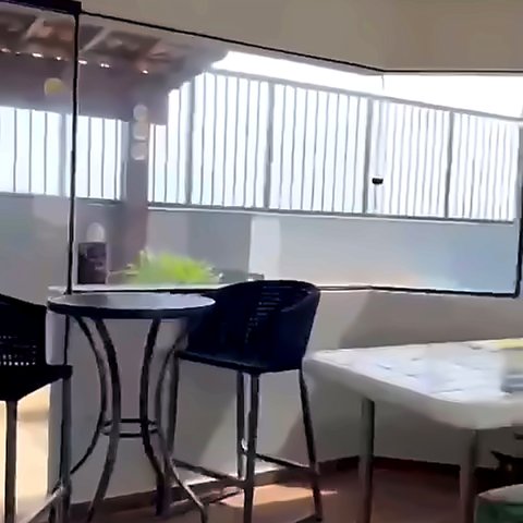 Área gourmet coberta com mesa alta e banquetas