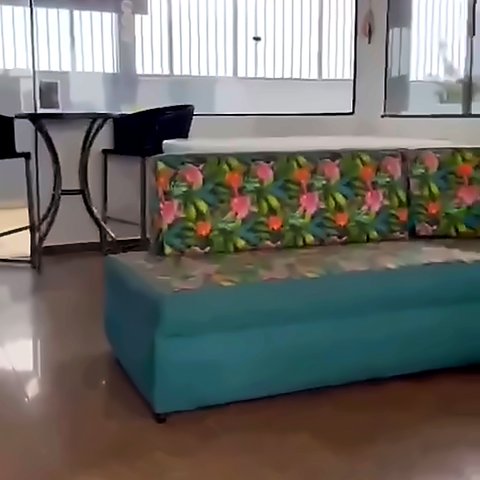 Sala do piso superior com sofá estampado e janelas amplas