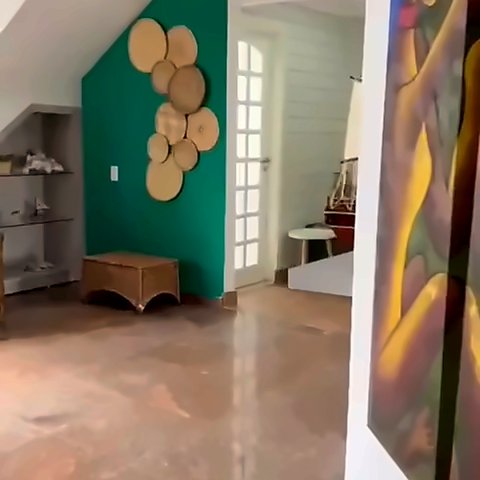 Sala de entrada com parede verde decorada e escada