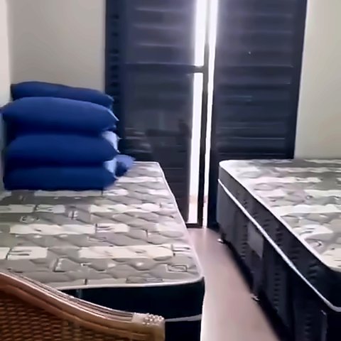 Quarto com camas e janela com persiana